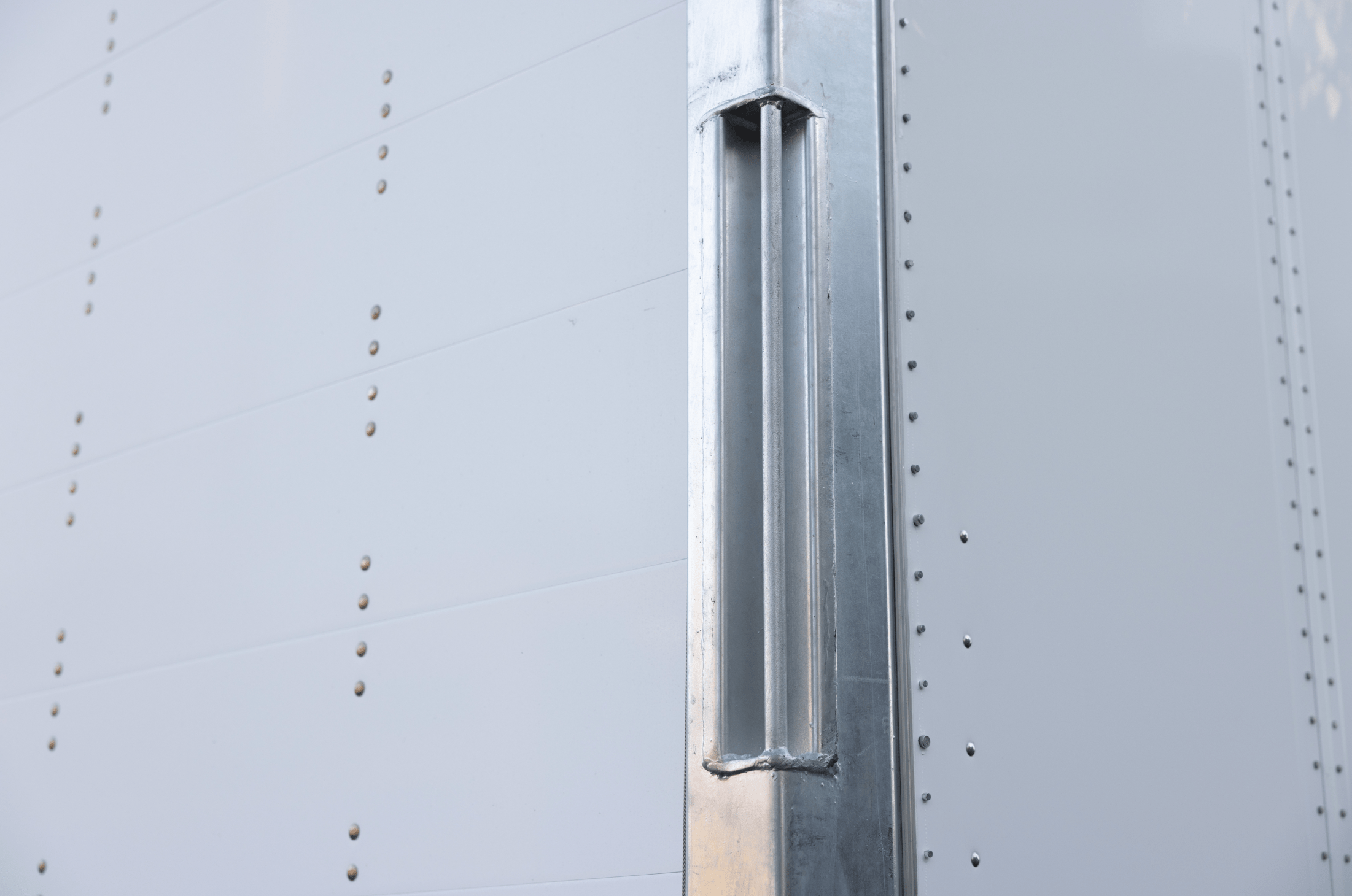 Close-up of the corner and side paneling of a Hyundai Translead Anza truck body or trailer, showcasing its durable construction and precise manufacturing, reflecting Hyundai's technology and innovation.